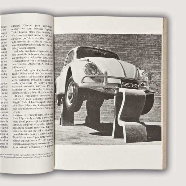 Volkswagen Beetle supported on all four wheels with cardboard side chairs